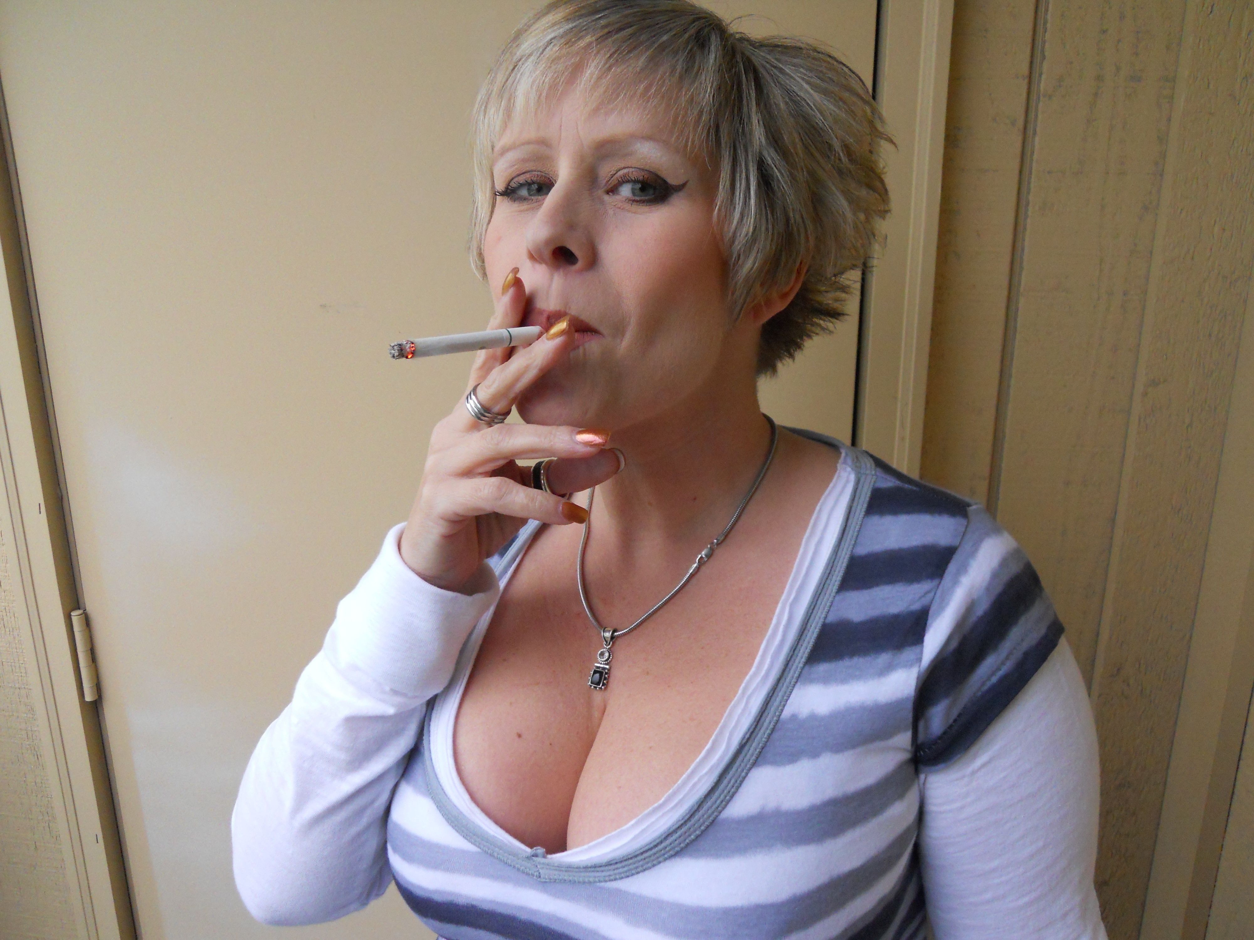 Блондинка перед веб камерой показывает большие сиськи и курит сигарету