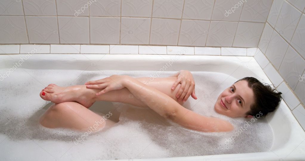 Молодая брюнетка раздевшись собирается принять ванну фото